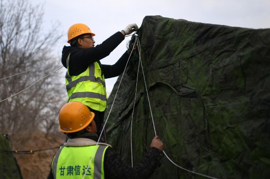 12月20日，甘肅省臨夏州積石山縣大河家鎮(zhèn)大河村集中安置點(diǎn)，工作人員在布設(shè)無(wú)線網(wǎng)絡(luò)。人民網(wǎng)記者 翁奇羽攝